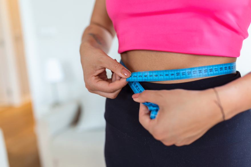 Tirzepatide before-and-after: a woman measuring her waist.